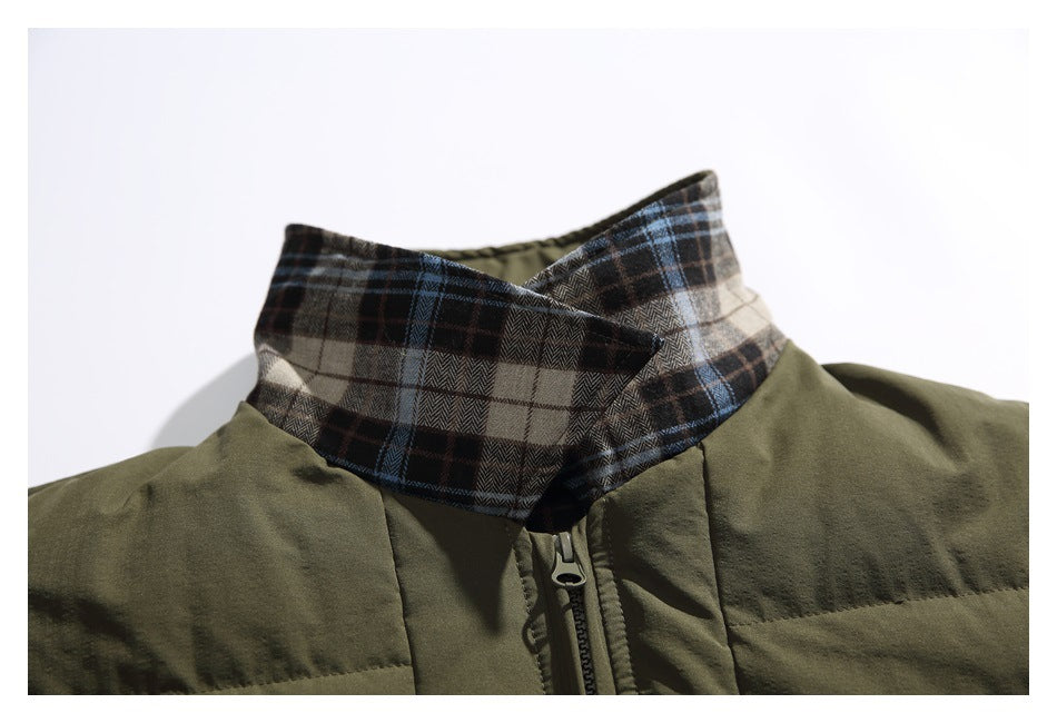 Close-up of an olive green jacket with a brown, gray, and blue plaid stand collar and front zipper.