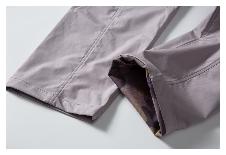 Close-up of pale mauve trousers showing stitched hems and a folded leg opening.