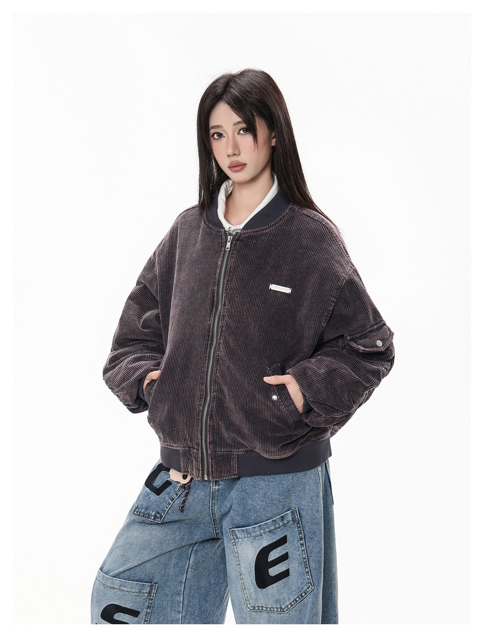 Closer front view of a model in a dark brown ribbed bomber jacket with a zip closure and front pockets.