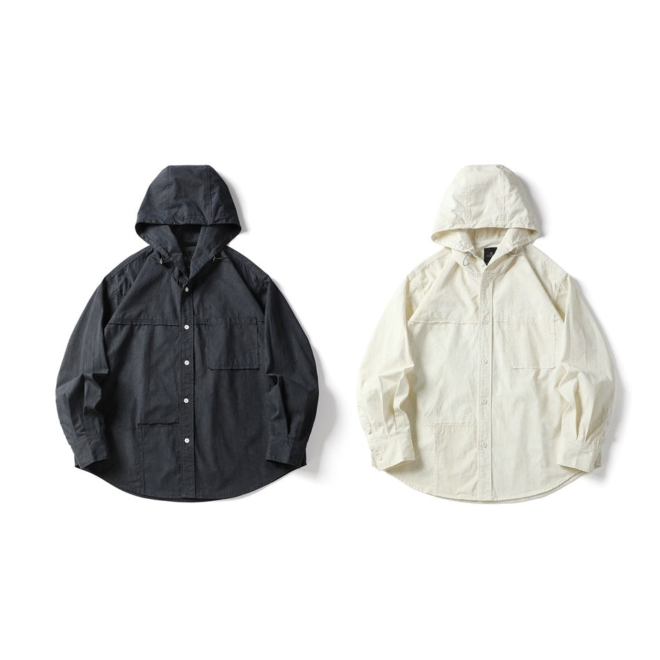 Two hooded button-front shirts shown from the front: one charcoal and one ivory, each with chest pockets.
