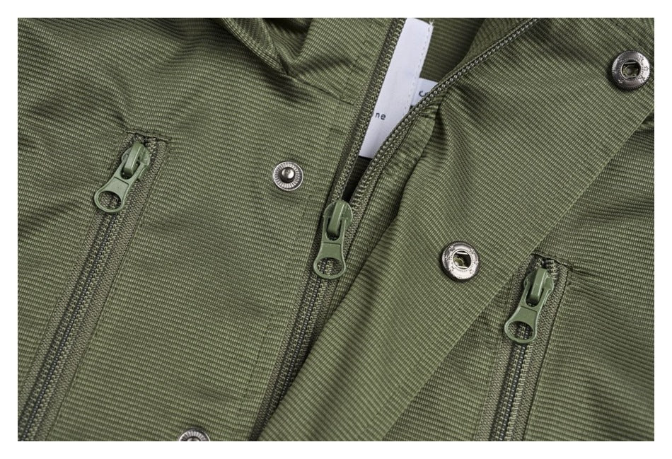 Close-up of the olive-green vest's front zippers, snap fasteners, and placket.