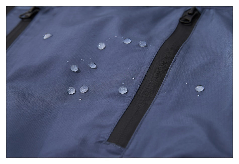 Close-up of water droplets on slate-blue jacket fabric beside a black zipper.