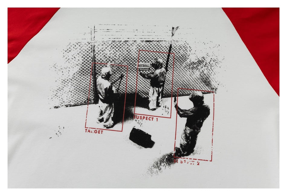 Close-up of a black-and-red graphic print on the white body of a raglan shirt.