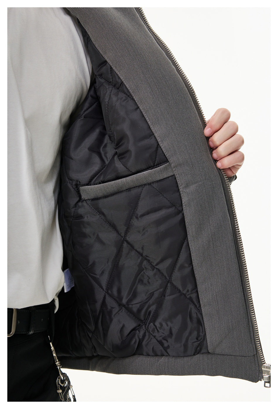 Close-up of the gray jacket opened to show its black quilted lining and interior pocket.