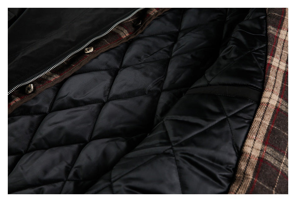 Close-up of the jacket's black diamond-quilted lining, zipper, and brown plaid trim.