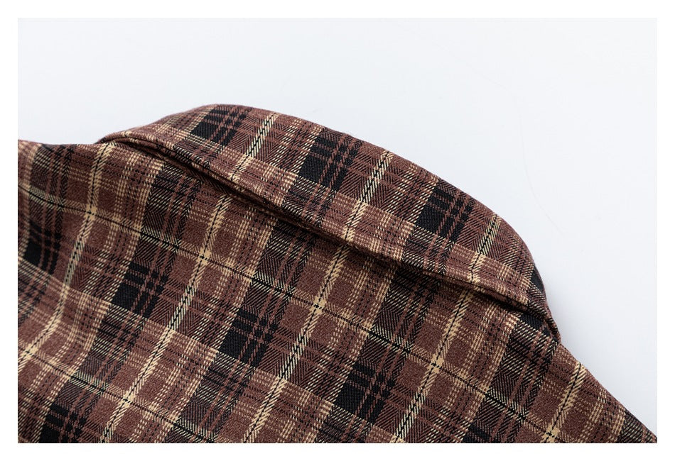 Close-up of a brown, black, and cream plaid garment collar and shoulder.