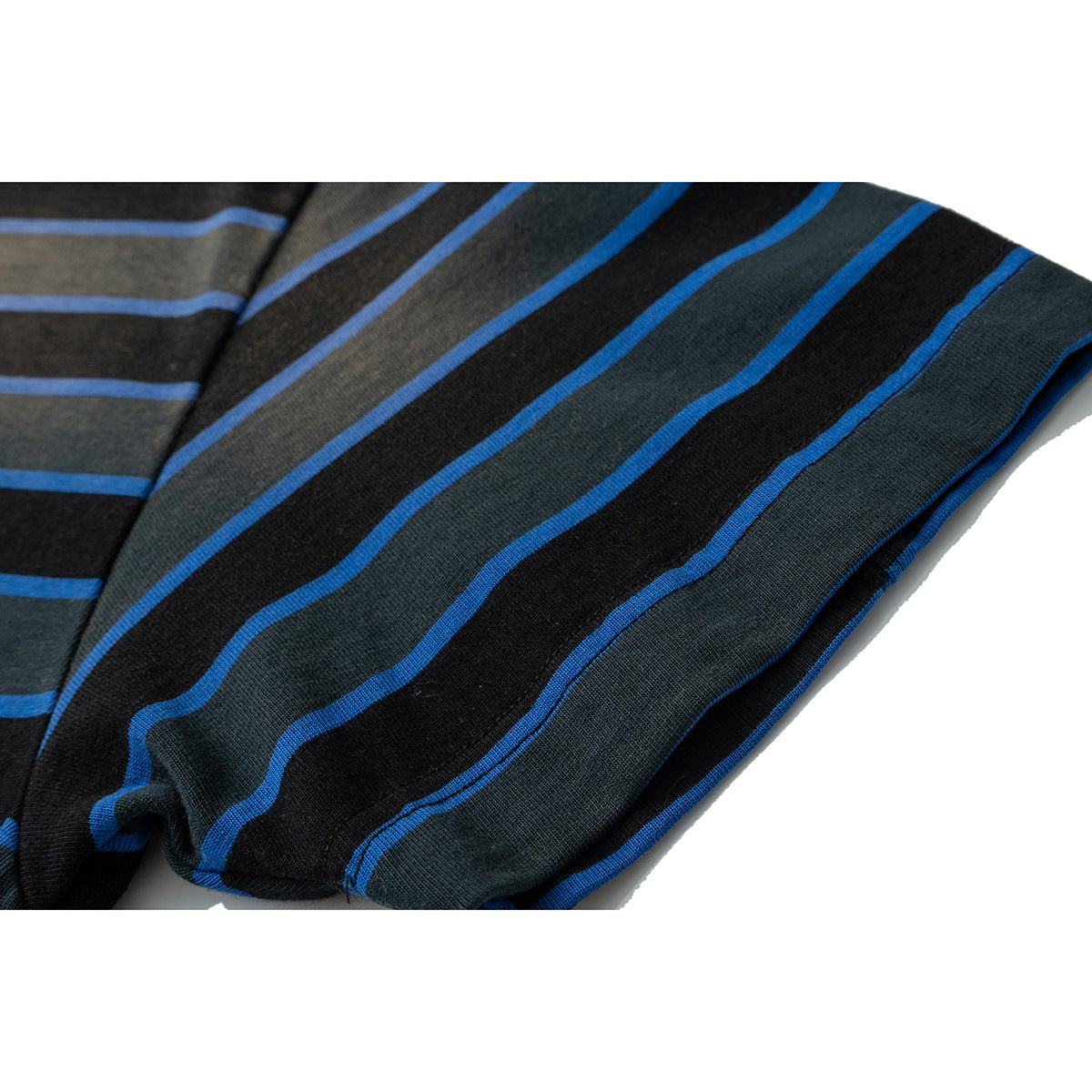 Close-up of a short sleeve on a black and dark charcoal striped T-shirt, with bright blue stripes and a finished sleeve hem.