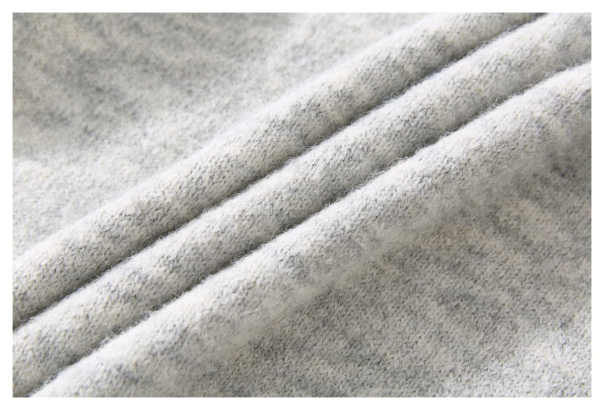 Close-up showing the fuzzy, marled knit texture of the light gray sweater.
