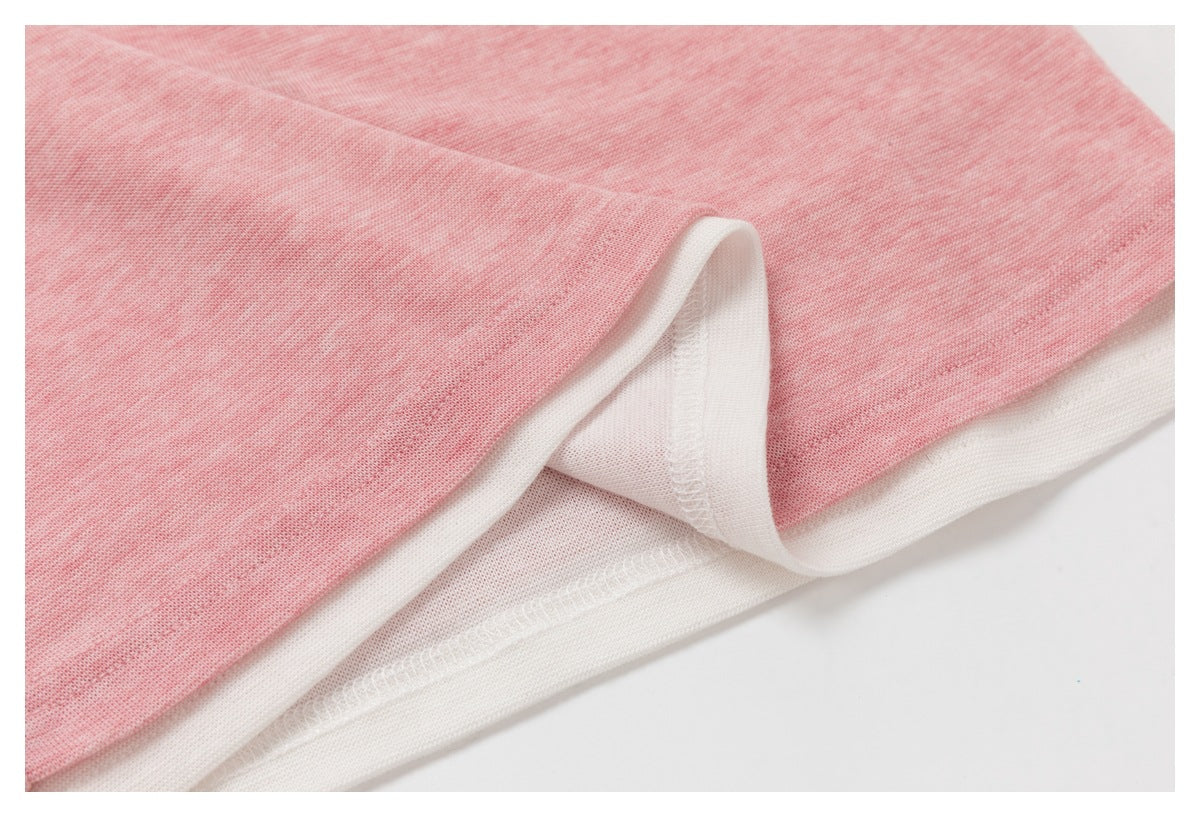 Close-up of the pink top’s hem folded back to show the white inner layer and stitching.