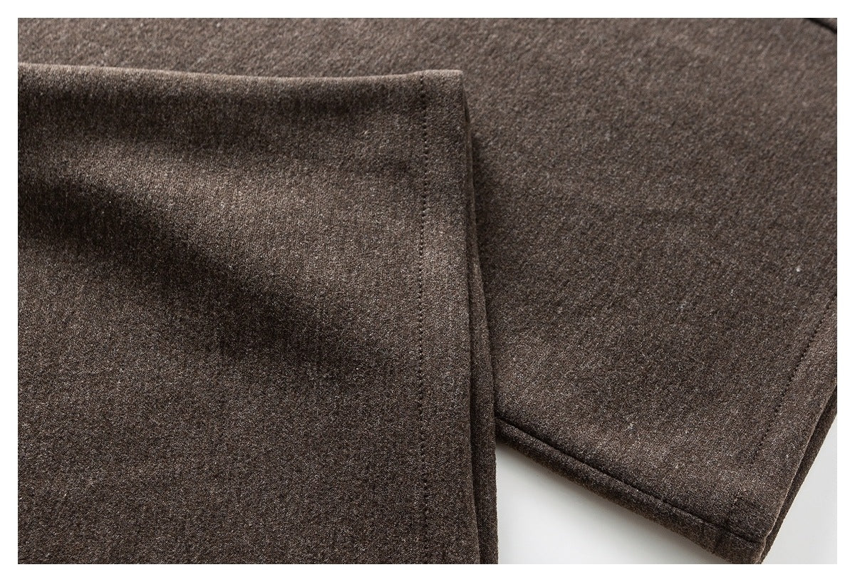 Close-up of brown trouser leg hems and stitched edges.