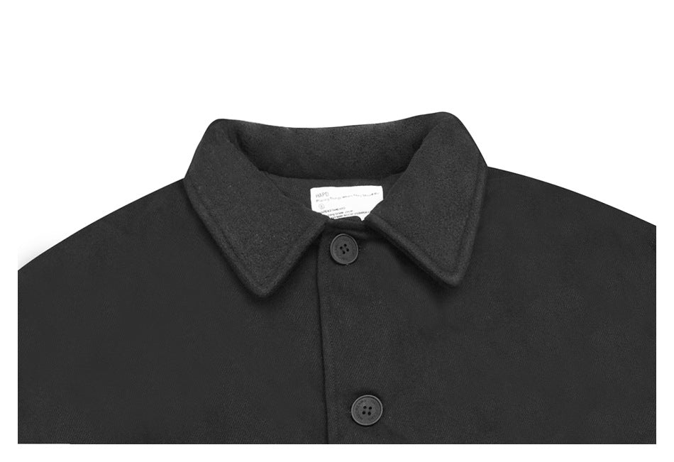 Upper front of a black coat with a wide pointed collar and dark buttons, shown against white.