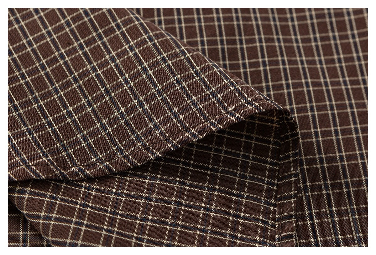 Brown plaid fabric draped in folds, showing cream and blue grid lines.