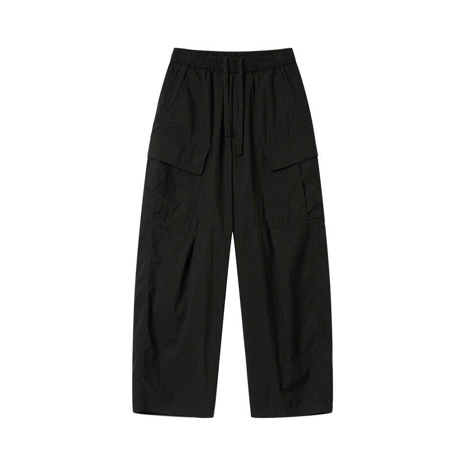 Black wide-leg cargo pants with drawstring elastic waist and large flap thigh pockets, front flat lay