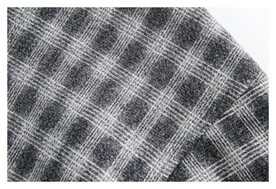 Close-up of gray and black plaid fabric with thin white intersecting lines.