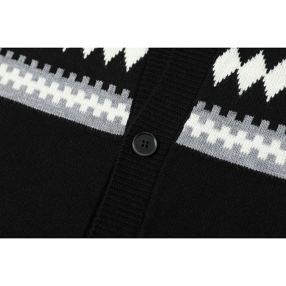 Close-up of the black knit shirt's button placket and white and gray geometric pattern.