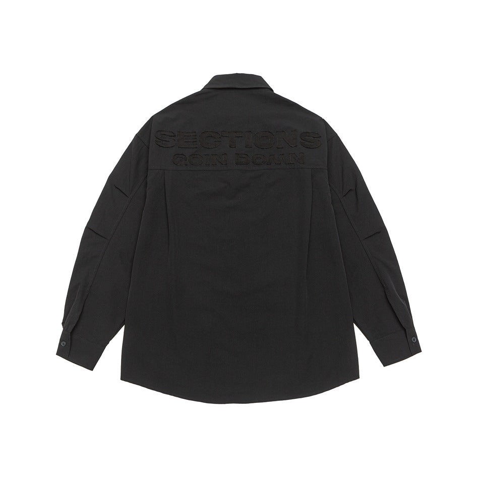 Black long-sleeve shirt, back view, with tonal embroidered lettering on the upper back and a yoke seam