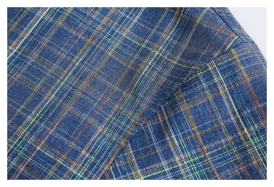Close-up of a blue multicolored plaid shirt sleeve seam and folded fabric.