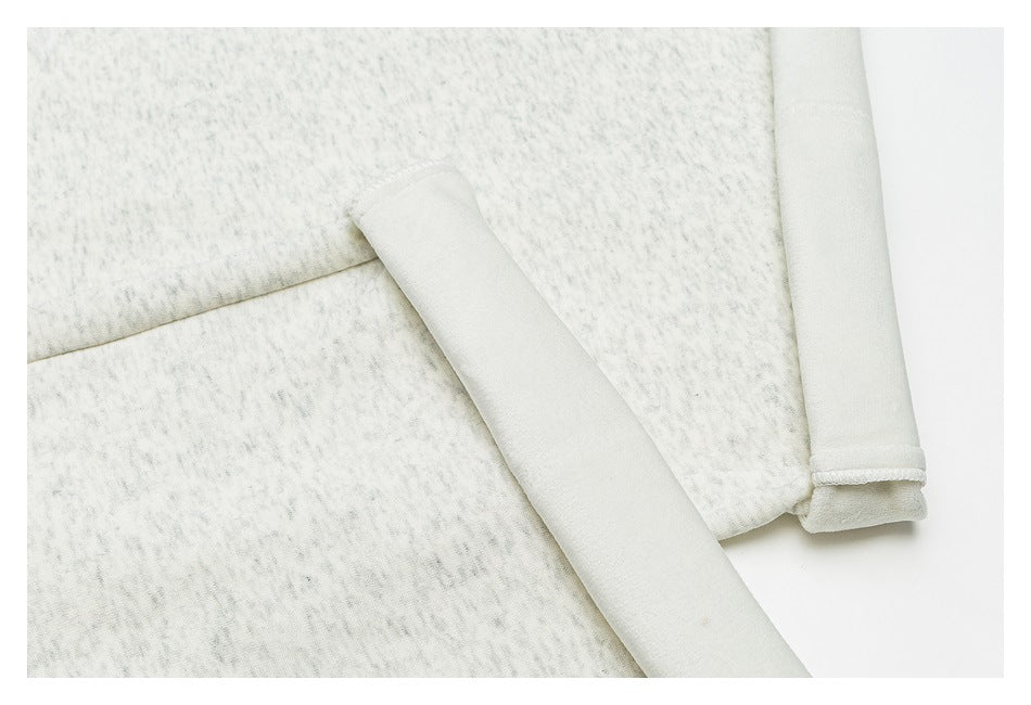 Close-up of light gray mottled garment with a folded edge and stitched hem.