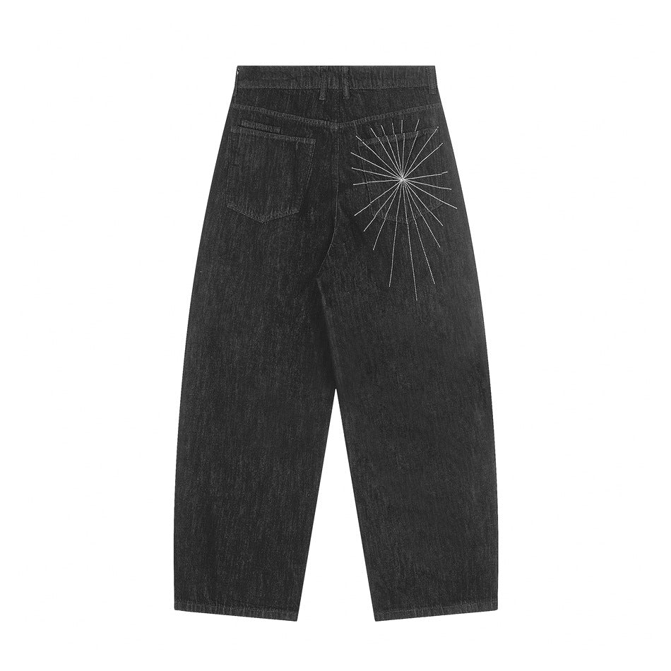 Back flat lay of black denim jeans with patch pocket and white starburst embroidery on the right back pocket