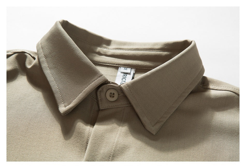 Close-up of a taupe shirt collar, top button, and visible neck label.