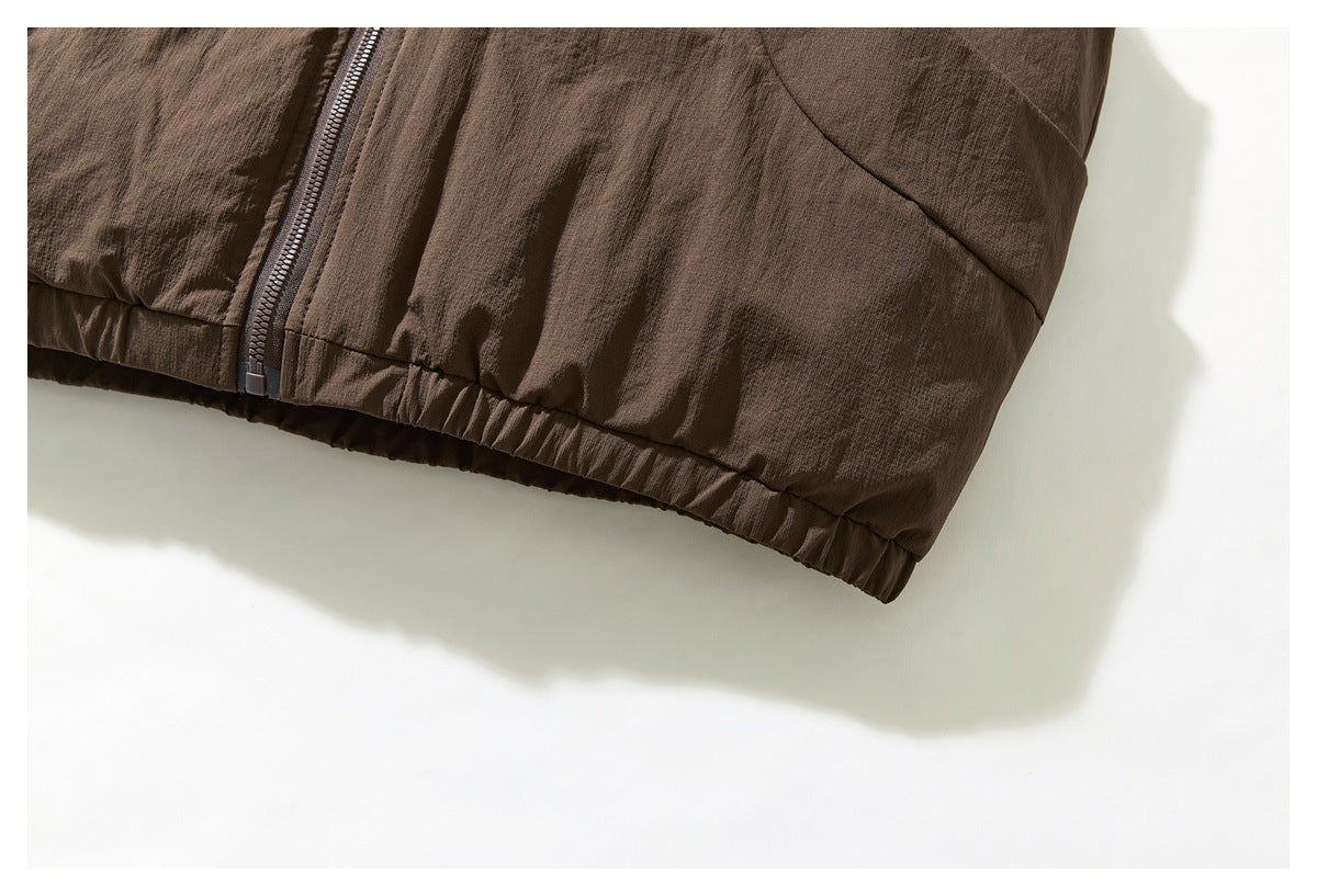 Close-up of the brown jacket's lower front zipper and gathered hem.