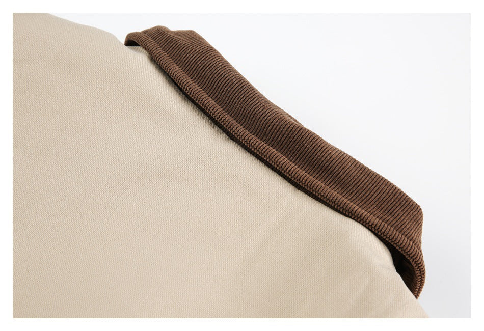 Close-up of a dark brown ribbed trim along the edge of the beige coat.