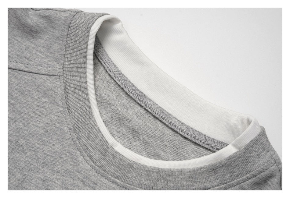 Close-up of a heather-gray crew neckline with white inner collar trim.