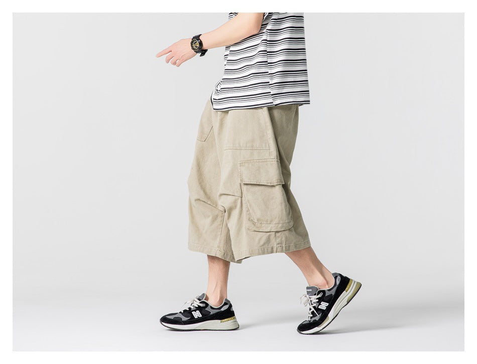 Side view of a model walking in light khaki knee-length cargo shorts with flap pockets.