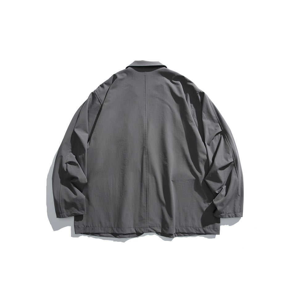 Back view of a charcoal gray jacket with a center seam, collar, and long sleeves on a white background.