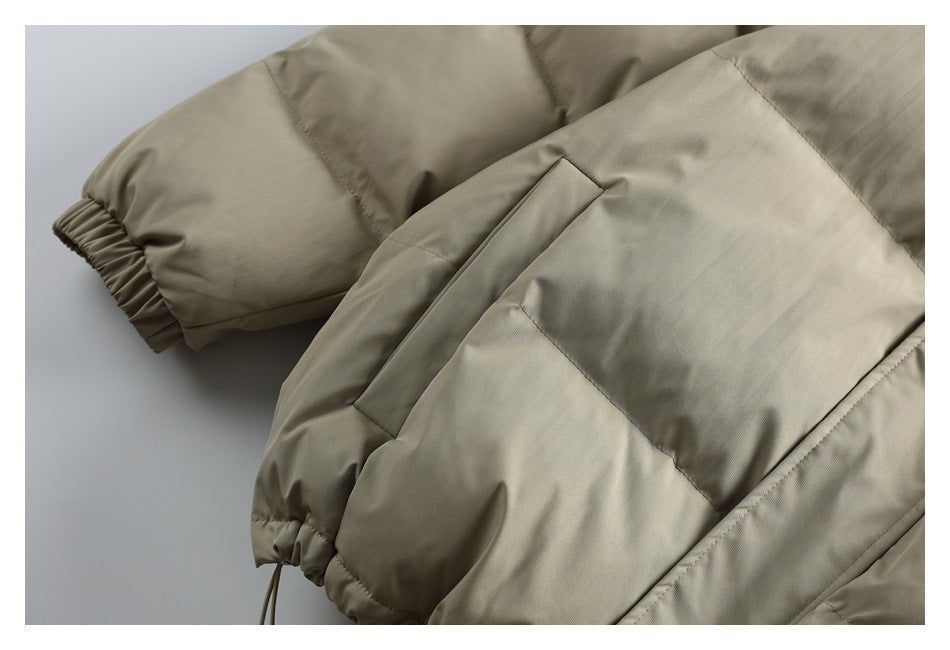 Close-up of a beige padded jacket’s side pocket, elastic cuff and gathered hem with an adjustment cord.