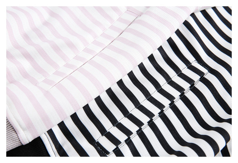 Close-up of pink-and-white and black-and-white striped hoodie fabric, showing seams and stitching.