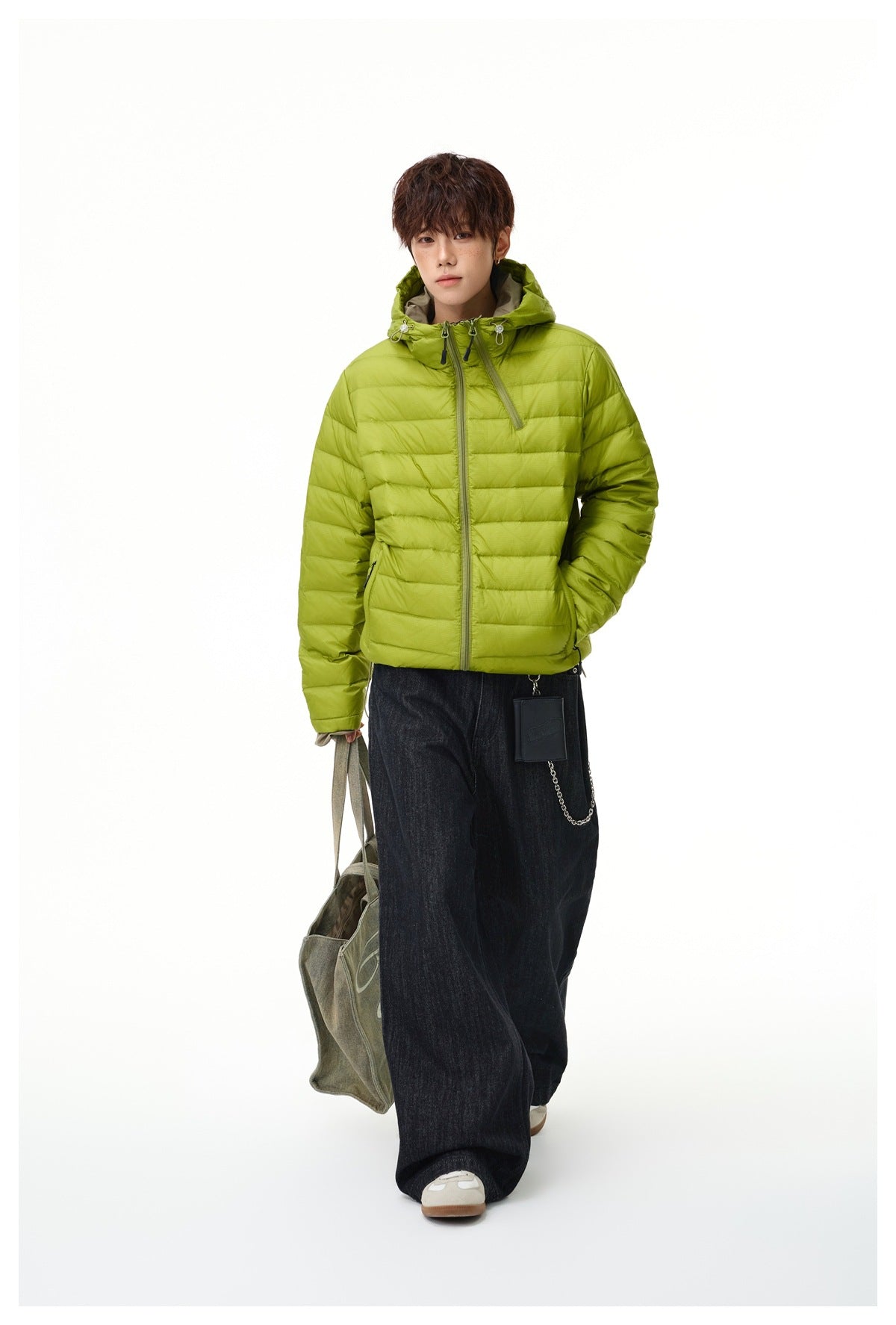 Full-length model wearing a lime-green hooded quilted jacket with wide dark jeans.