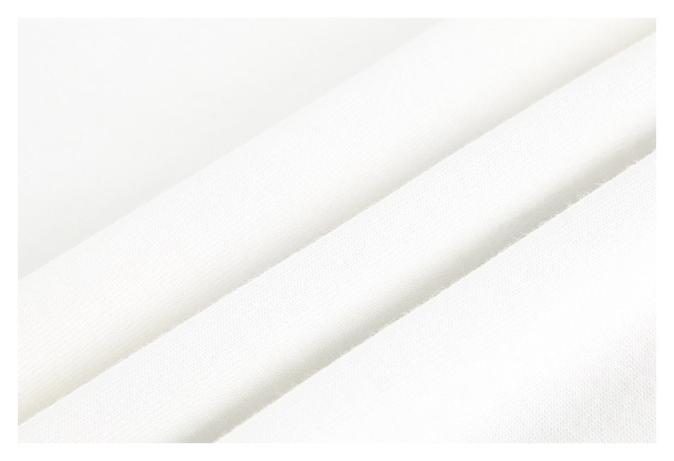 Close-up of white fabric showing its fine knit texture and folded layers.