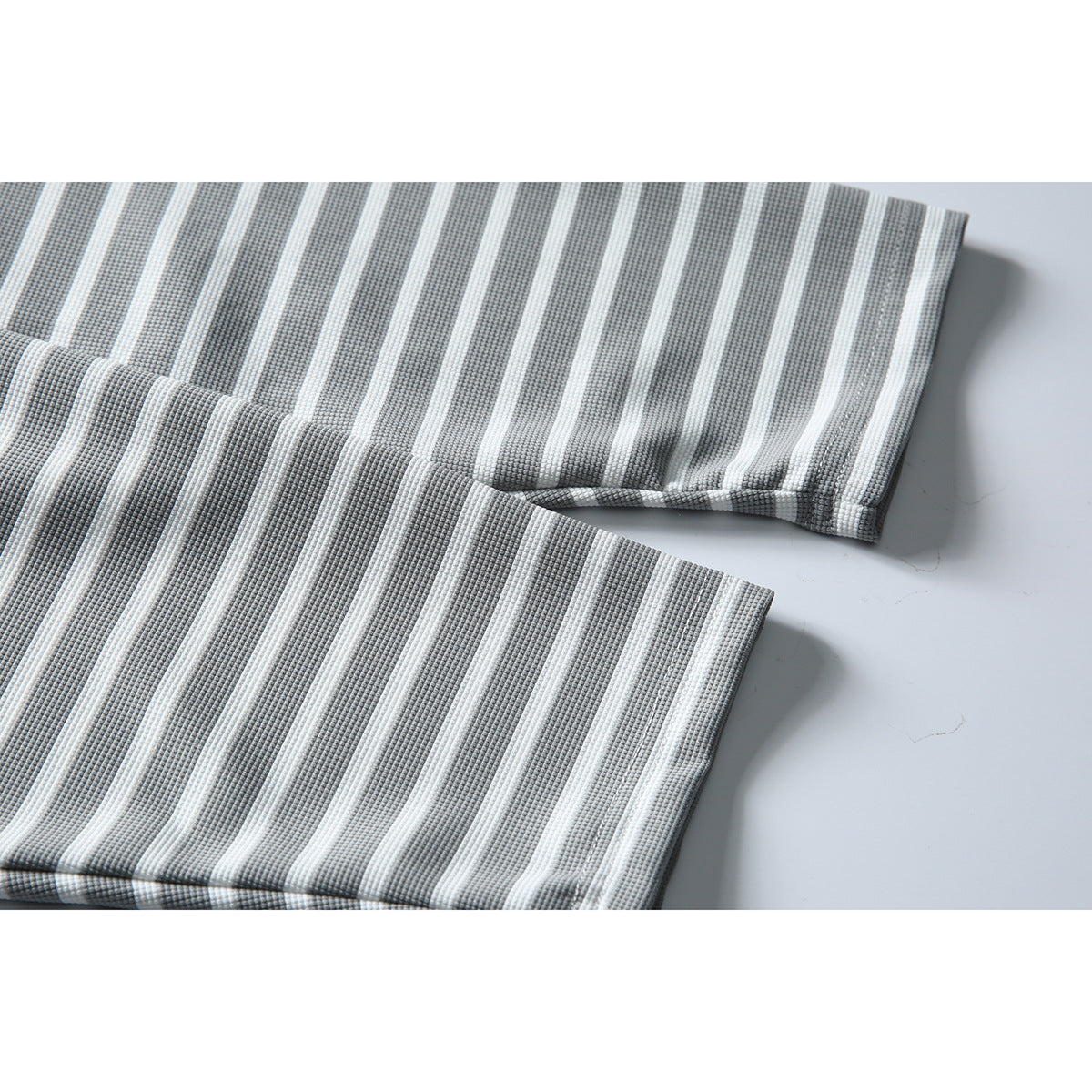Close-up of the gray-and-white striped shirt's sleeve and hem edges.