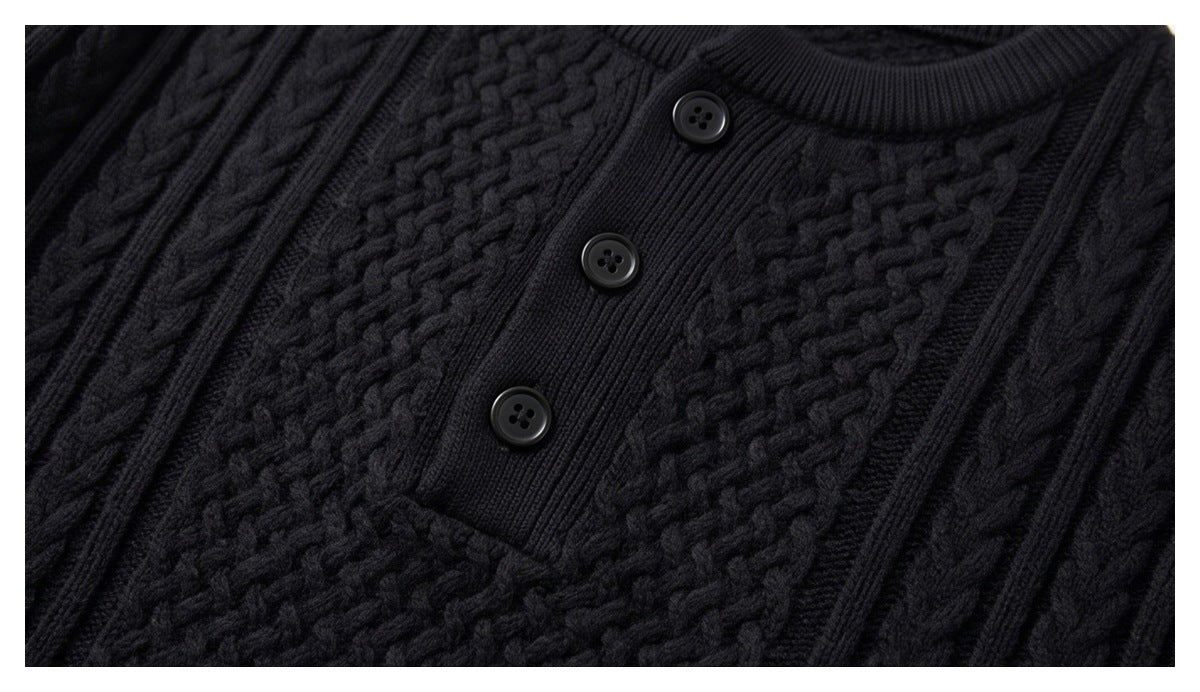 Close-up of three dark buttons on a ribbed placket against the sweater's raised black knit pattern.