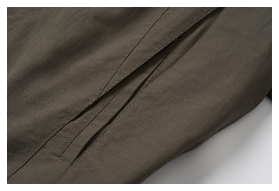 Close-up of a long narrow pocket opening on the brown jacket.