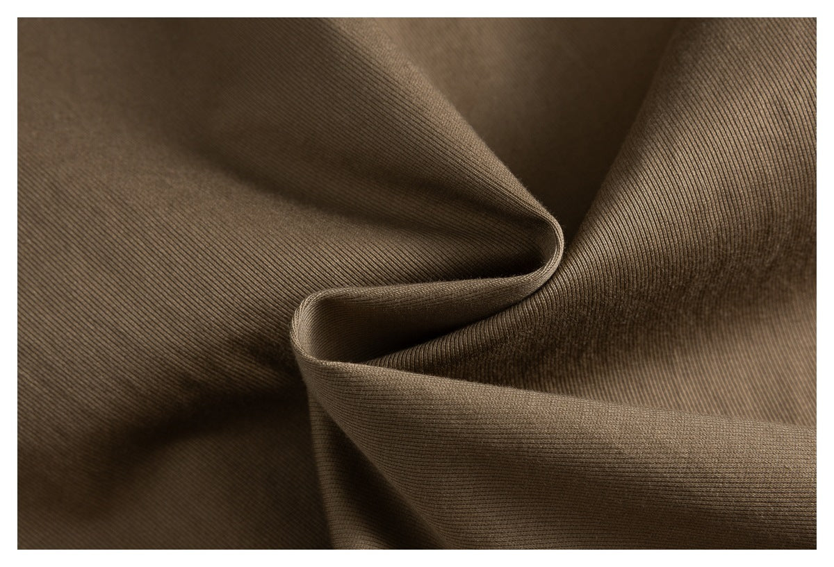 Close-up of brown fabric draped into folds, showing its fine ribbed texture.