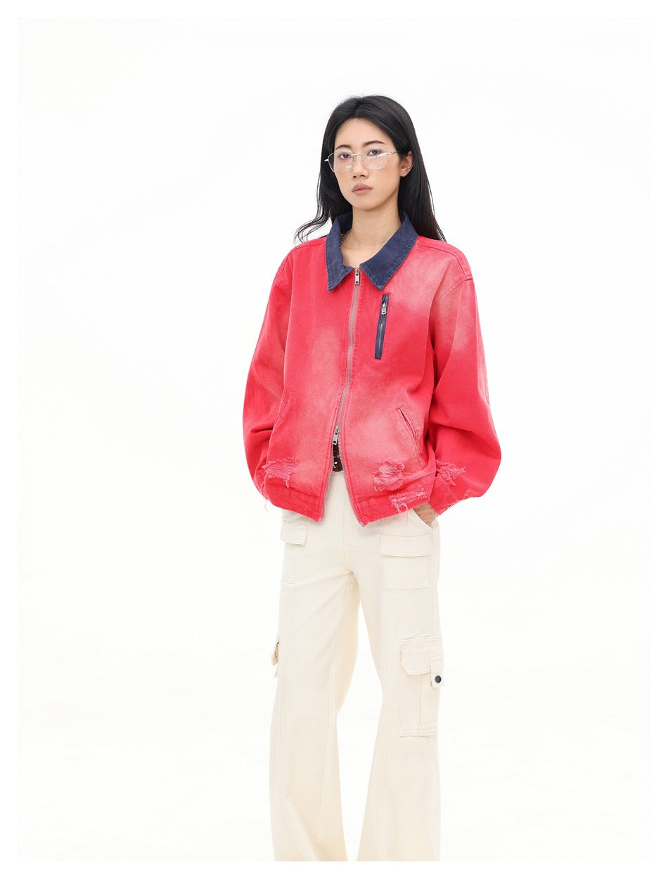 Three-quarter view of a model wearing a coral-red zip jacket with a dark blue collar and cream cargo pants.