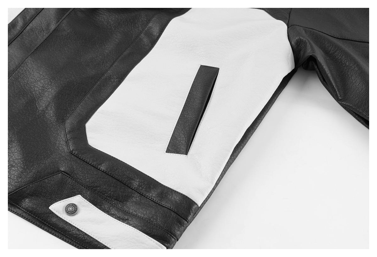 Close-up of a black-and-white jacket showing a white panel, black trim, and a snap-fastened pocket.
