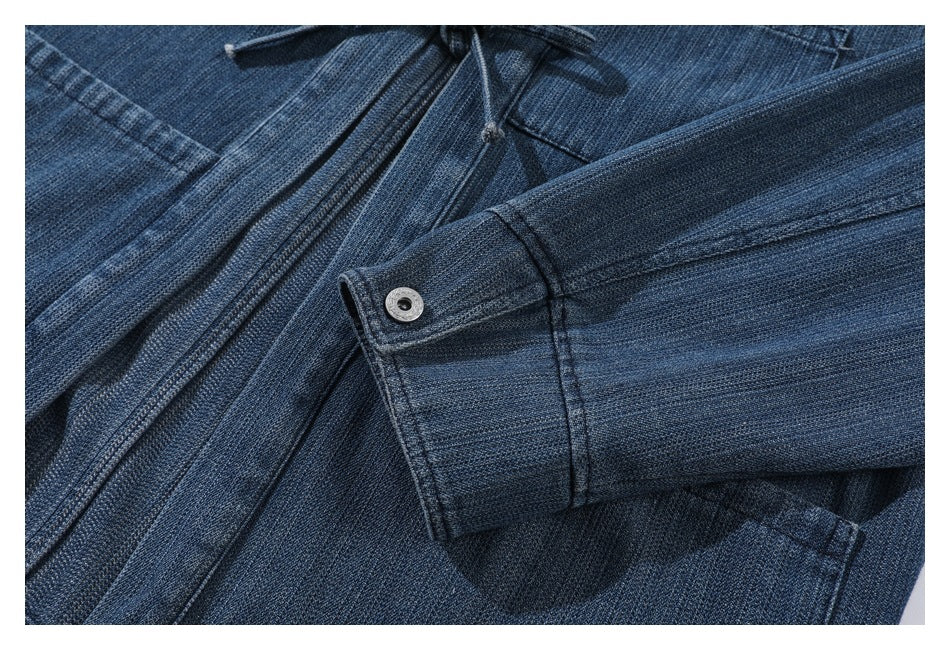 Close-up of a denim sleeve cuff with a metal snap beside the garment's waist tie.