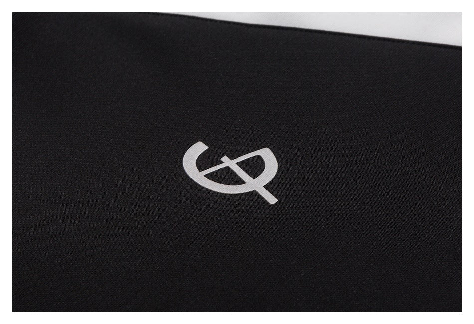 Close-up of a small white abstract logo on black fabric.