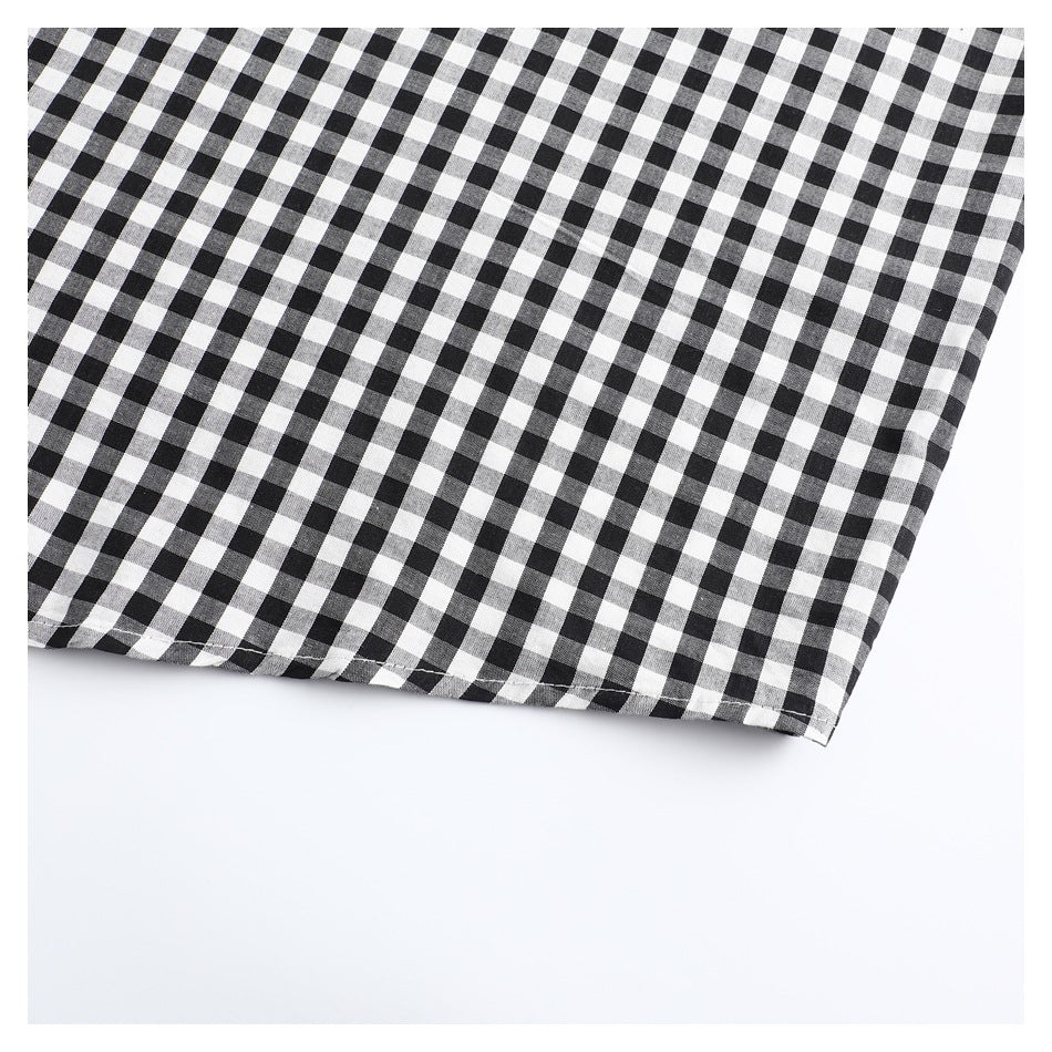 Close-up of the hem of a black-and-white gingham shirt.