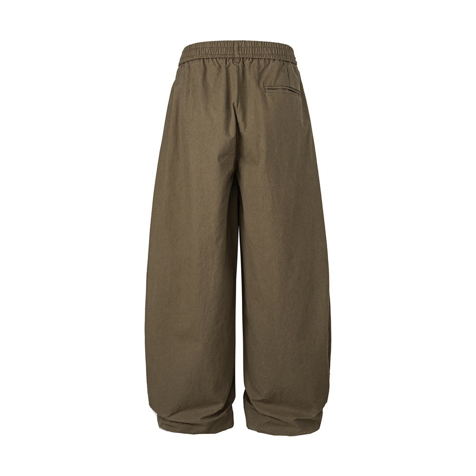 Back view of olive-brown wide-leg trousers with an elastic waistband and a small welt pocket.