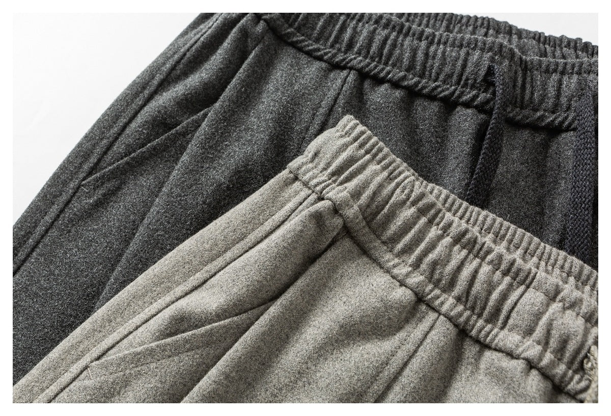 Close-up of charcoal and light gray pants showing their elastic waistbands and soft-looking fabric.