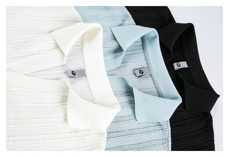 Close-up of white, pale blue, and black textured polo shirts arranged together, showing their collars.