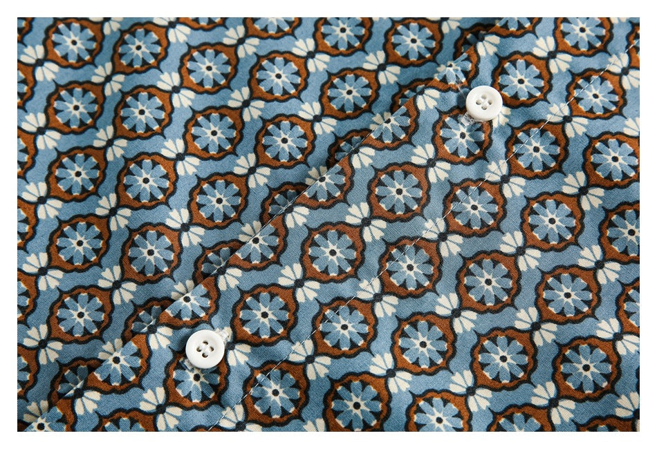 Close-up of a blue floral shirt front with a diagonal button placket and white buttons.
