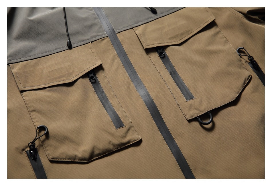 Close-up of a tan jacket front with two flap pockets, vertical zippers and dark trim.