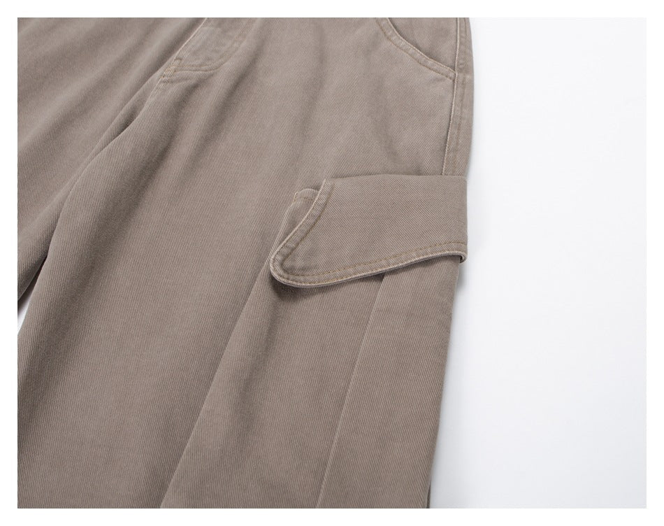 Close-up of a taupe trouser leg cargo pocket with a wide flap.