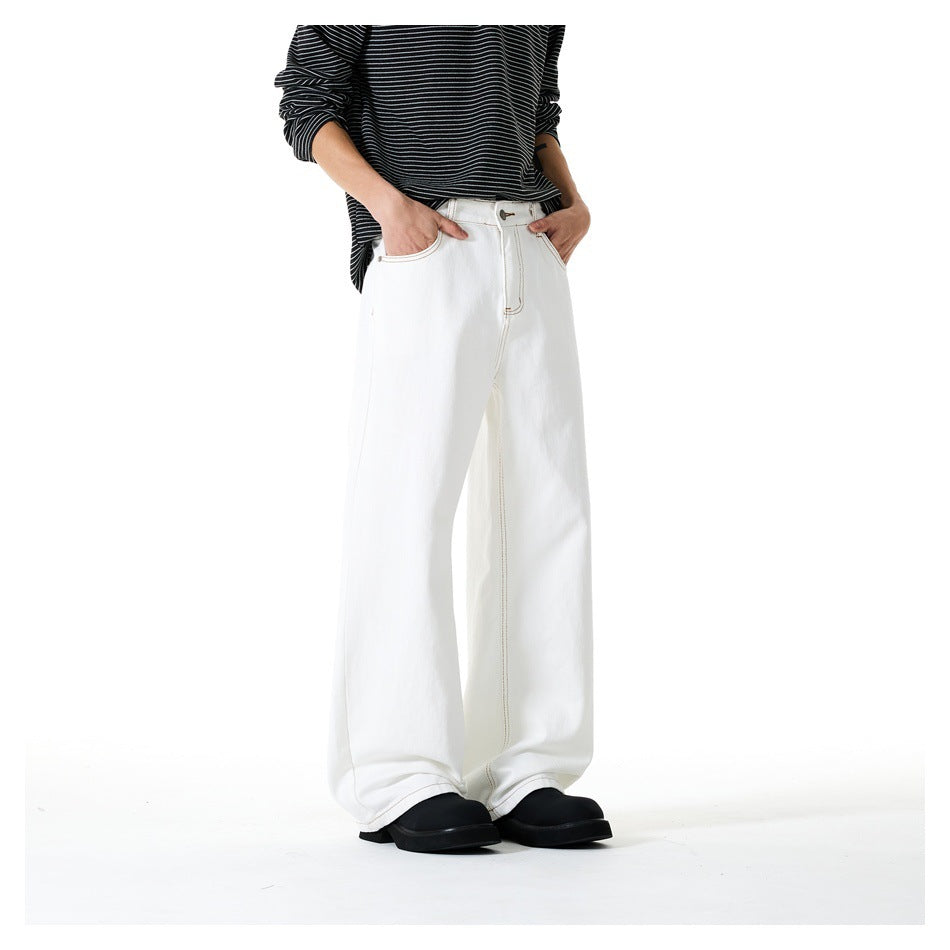 Angled front view of a model wearing white wide-leg pants with contrast stitching and a black striped top.