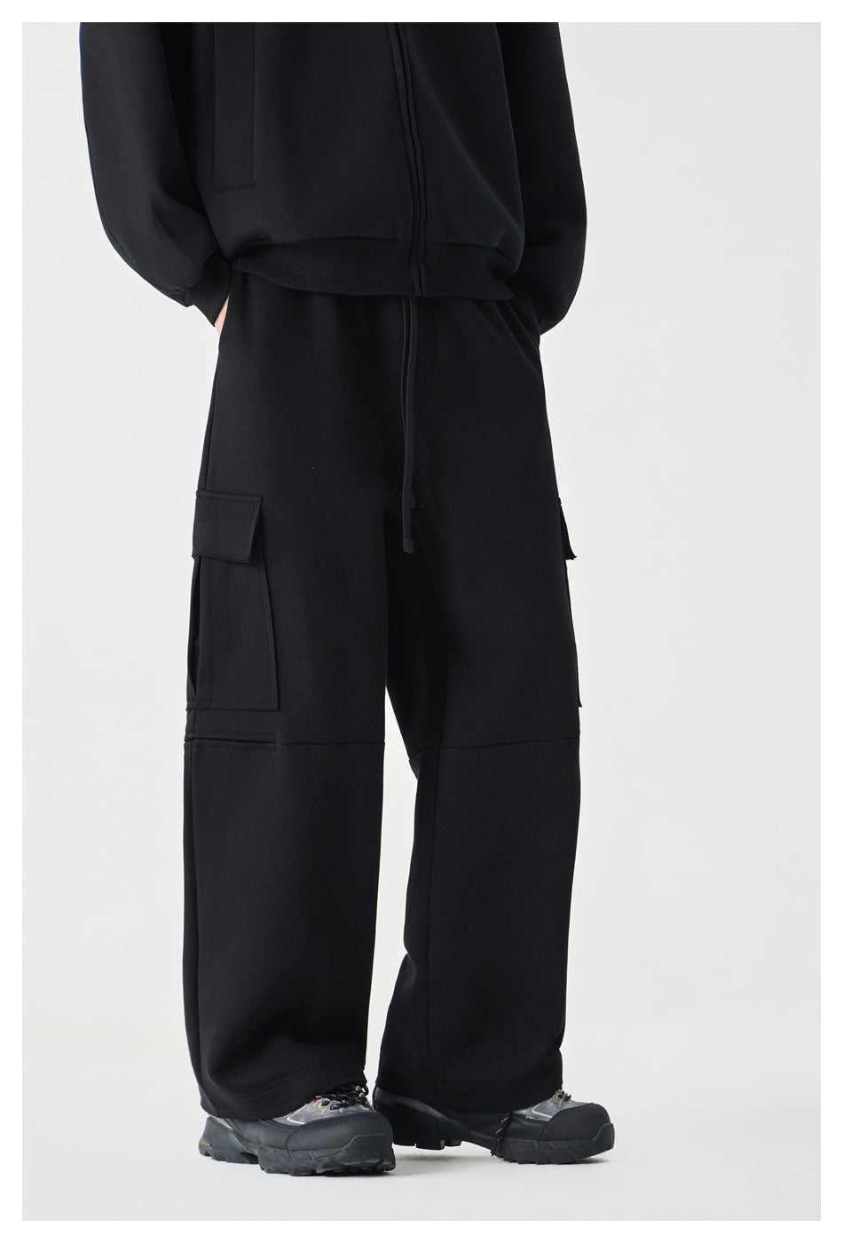 Cropped model wearing black wide-leg cargo pants with cargo pockets, shown from a side angle.